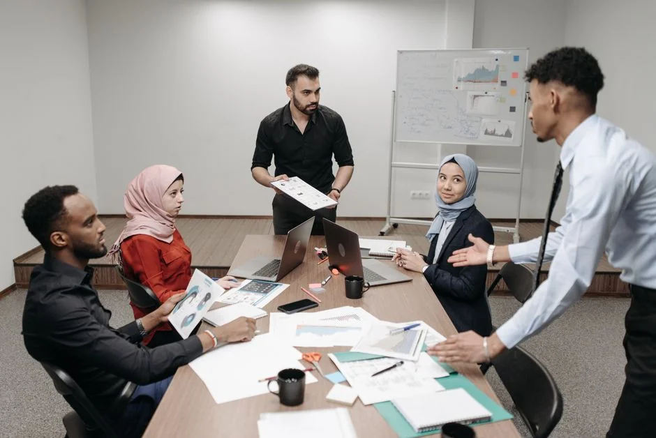 Team working on marketing strategy using data charts and papers in an office meeting.
