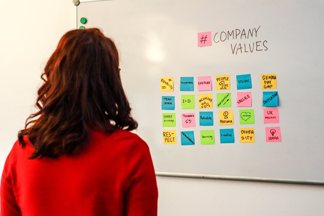 A woman standing in front of a white board with company values written on it